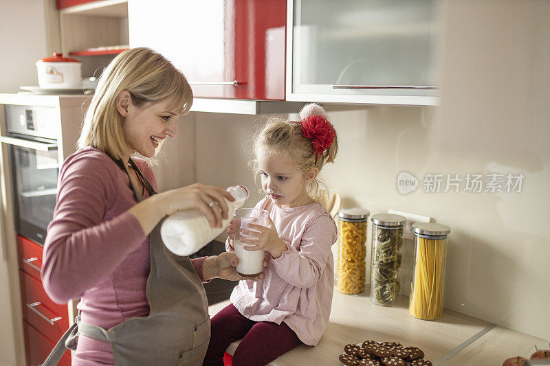 母亲和女儿在现代化的厨房里喝牛奶