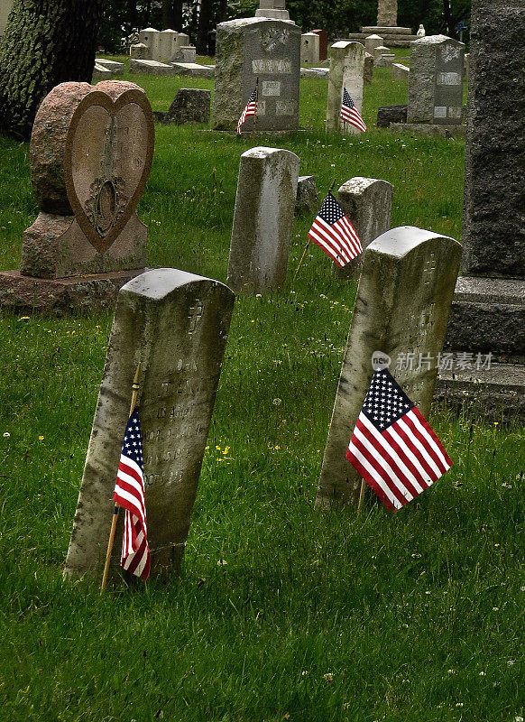 在阵亡将士纪念日，纽约格林波特，美国国旗在退伍军人的墓碑旁插上