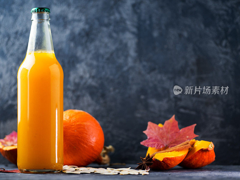 一瓶自制的南瓜汁，桌上放着新鲜的南瓜与拷贝空间。健康的天然饮料