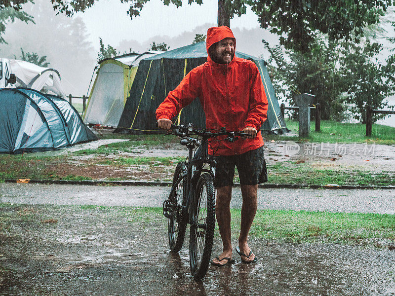 一名山地摩托车手冒着暴雨回来露营