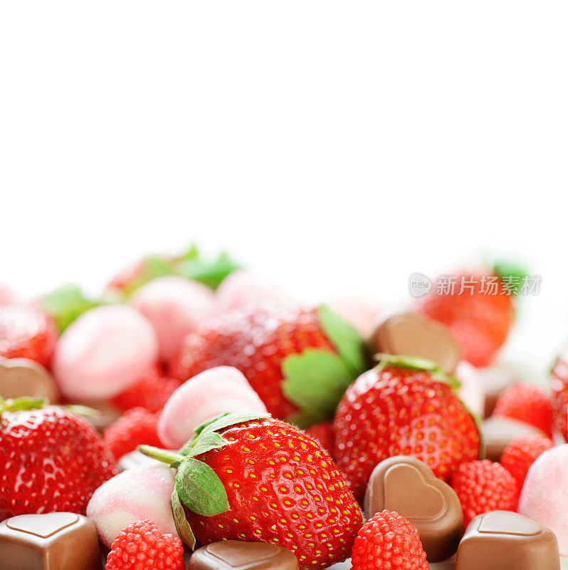明亮美丽的糖果和草莓在白色的背景