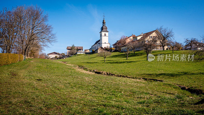 田园诗般的风景。瑞士村庄的全景，有农田，教堂和房屋。