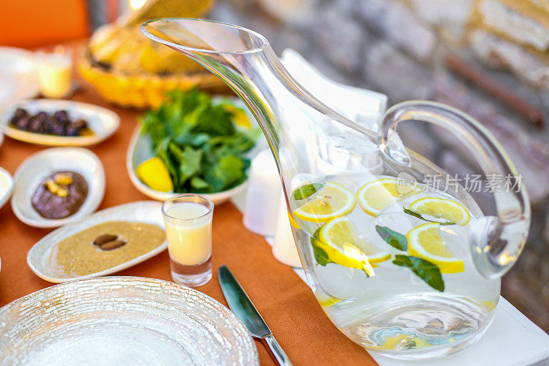 在早餐桌上放有柠檬片和薄荷叶的水壶