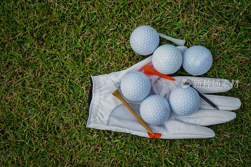 草地上的高尔夫设备，球，手套，球座和高尔夫球俱乐部的司机，高尔夫设备和设备在平铺俯视图