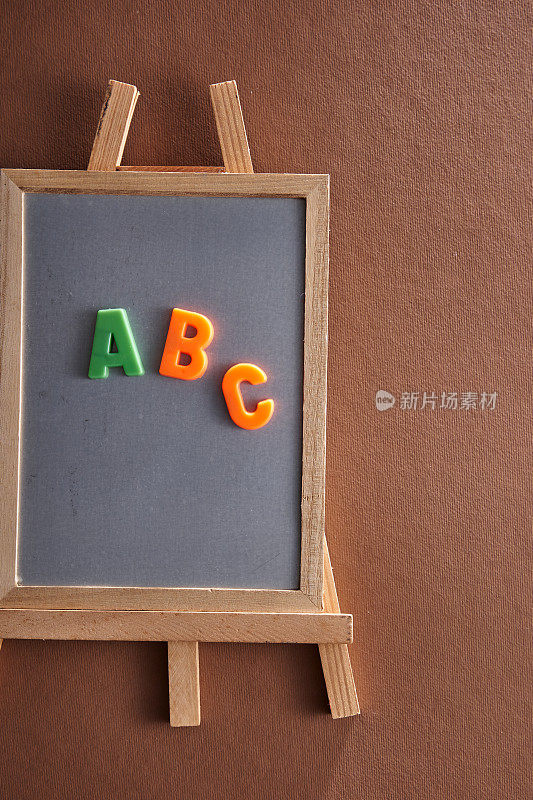 字母ABC在磁性板上与棕色背景的画架