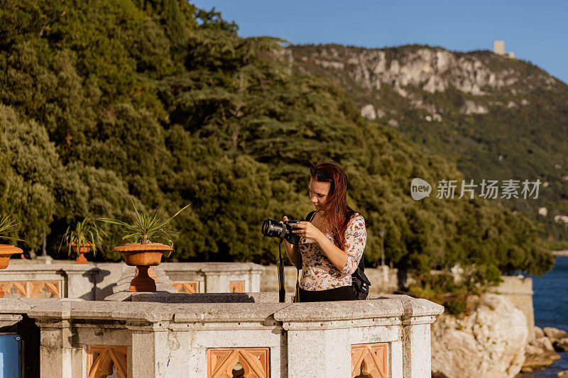 好奇的女摄影师正在用她的相机拍摄令人惊叹的里雅斯特