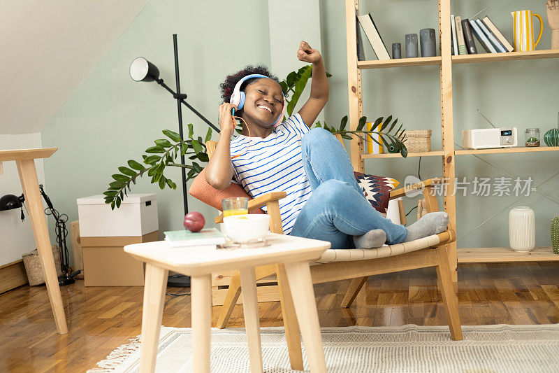 年轻的非洲妇女在她的客厅里享受着她最喜欢的音乐