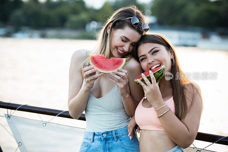 姑娘们在河船上吃西瓜