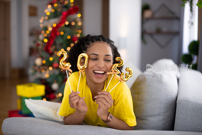 快乐的女人在家里庆祝新年库存照片