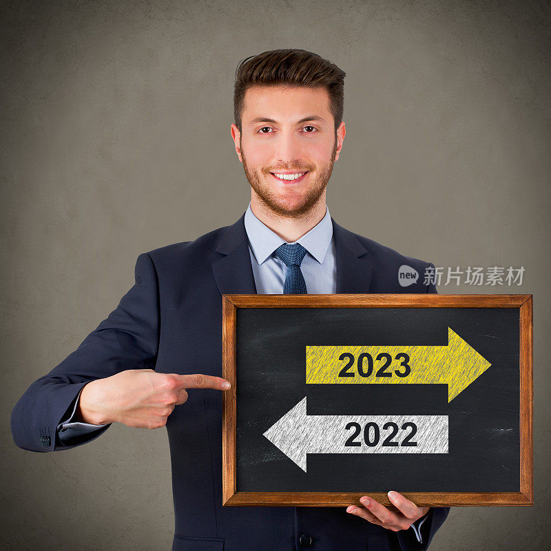 商人在黑板背景上画旧年或2023年