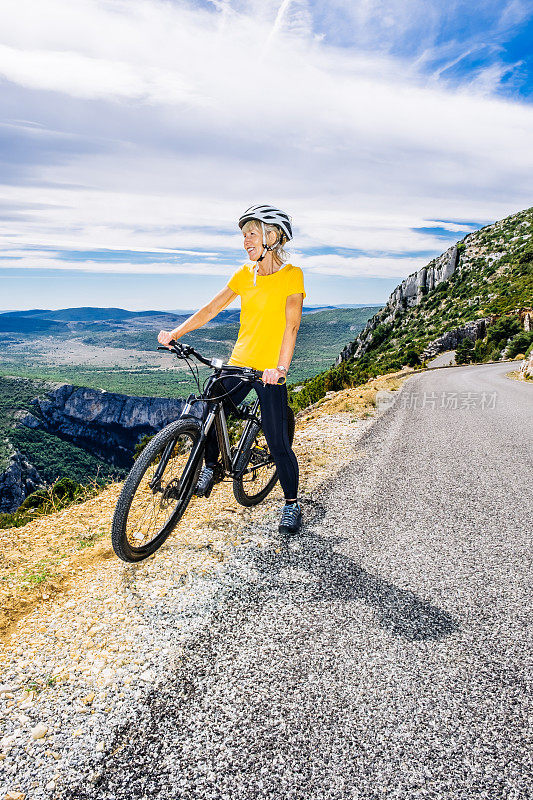 在法国普罗旺斯Verdon峡谷的克里特斯大道上，骑自行车的女子在蒂勒乌尔的贝尔维德塔上