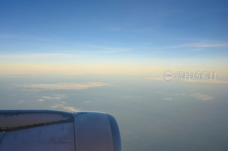 飞机在云层自然条件下飞行，以窗口观赏日出时刻