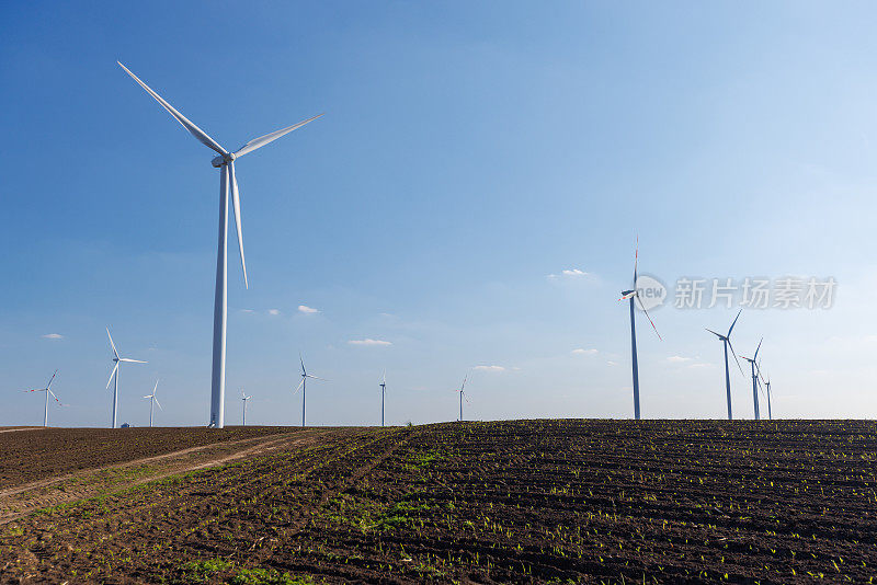 蔚蓝的天空下，农田上的风力发电机
