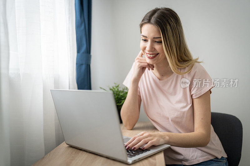 女商人在酒店房间里用笔记本电脑工作。