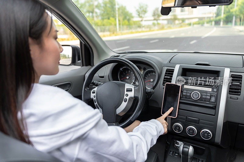 年轻女子开车时使用手机的侧视图