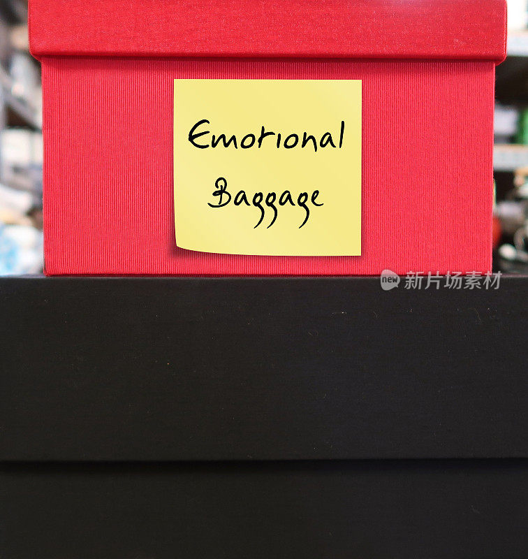 红色和黑色的盒子，上面有便签，上面写着“情感包袱”——把过去所有的失望、错误和创伤放在一个沉重的包袱里，消极的、未经处理的来自过去经历的情感