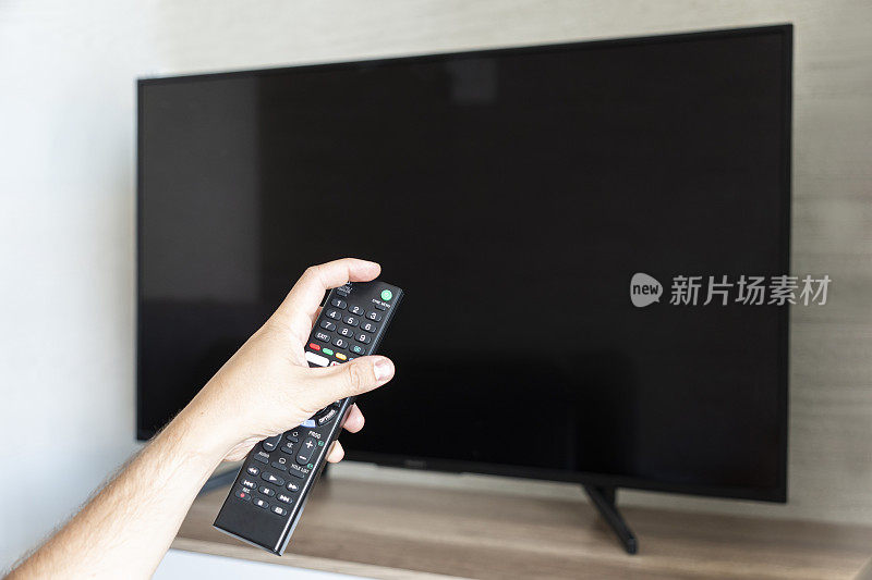 电视遥控器用拇指在电视屏幕上切换频道