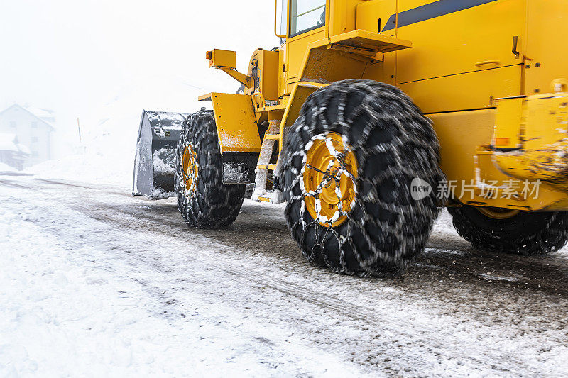 挖掘机在冬天从路上挖雪