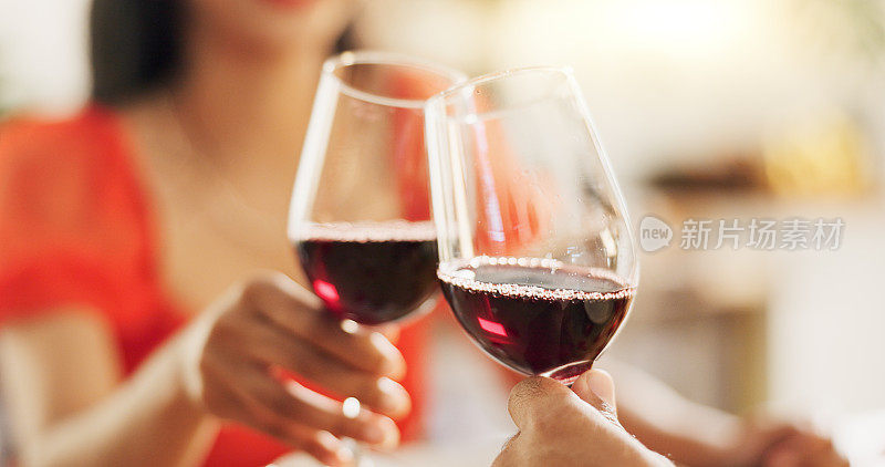 情侣们，手牵手，用红酒举杯庆祝爱情、浪漫和他们的结婚纪念日。人们或恋人约会时用酒杯、饮料和酒精来庆祝、成功和奢华