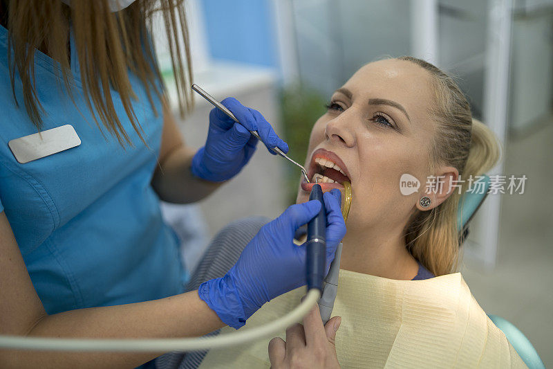 一名年轻女子在牙医诊所接受牙齿检查。年代