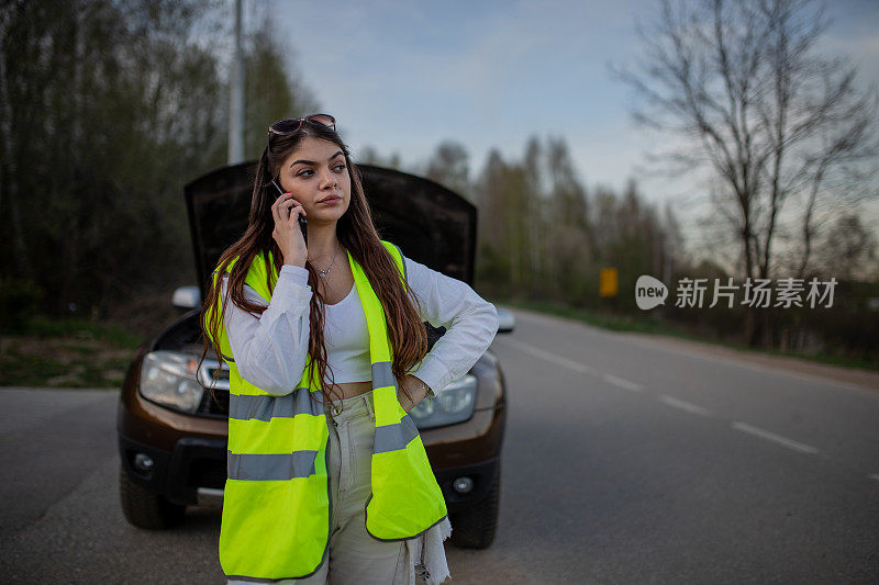 一名年轻的压力大的女子在被困在路边时用手机求救