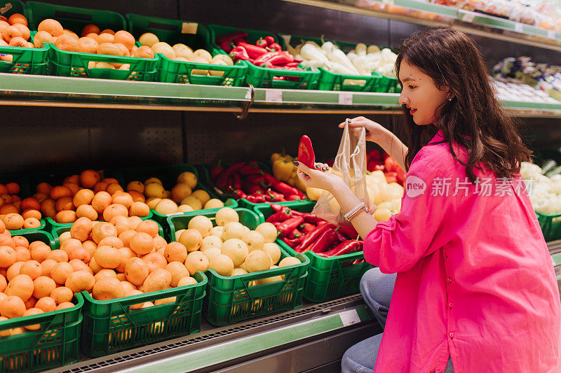 年轻的韩国妇女在杂货店购物时不带塑料袋。素食零浪费女孩在超市挑选新鲜水果和蔬菜。系列的一部分