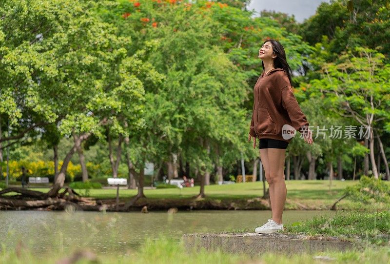 年轻的亚洲女性在公园里享受清风