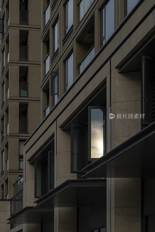 日出的景象映照在一座现代建筑的玻璃窗上