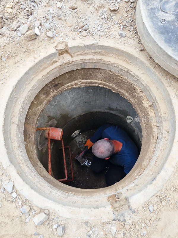 在旧粘土陶瓷下水道管道上工作的人