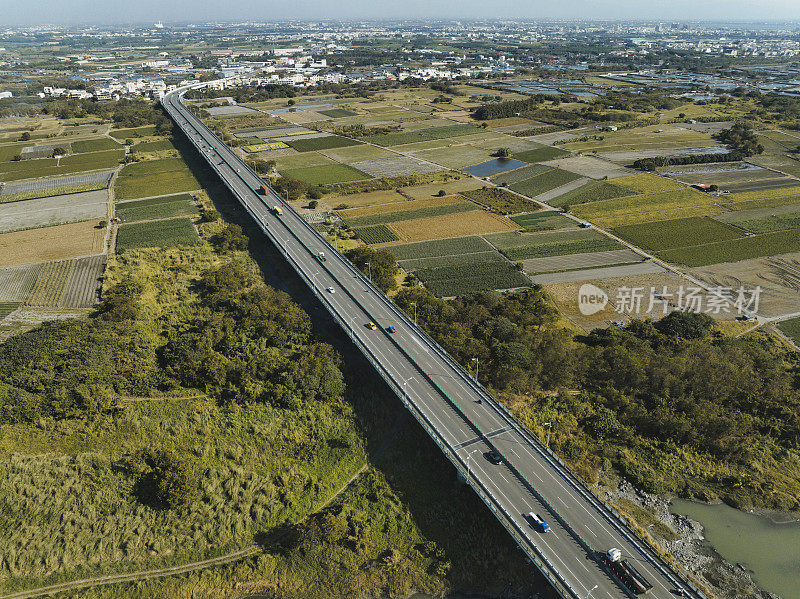 汽车在高速公路路口行驶的鸟瞰图。桥梁道路与绿色花园和树木连接的建筑概念