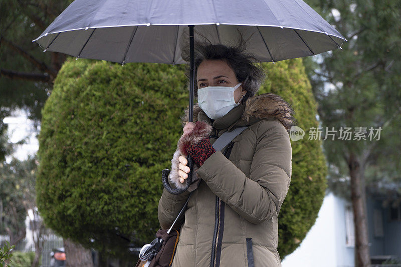 在冬天的雨天，女人在街上等待