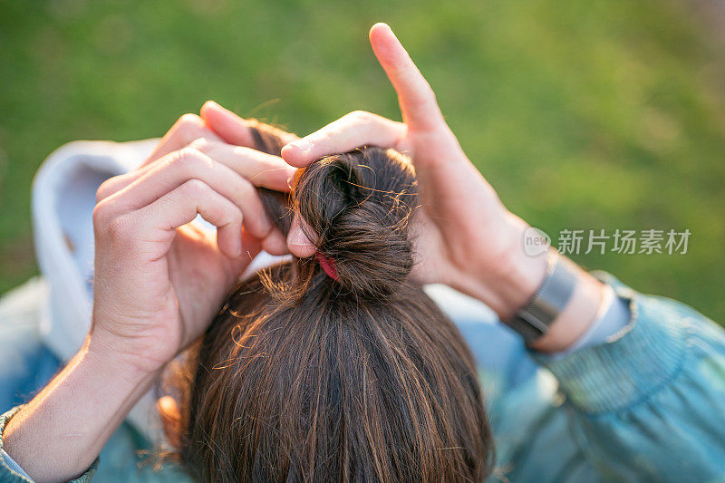 一个男人把他的头发盘成圆髻