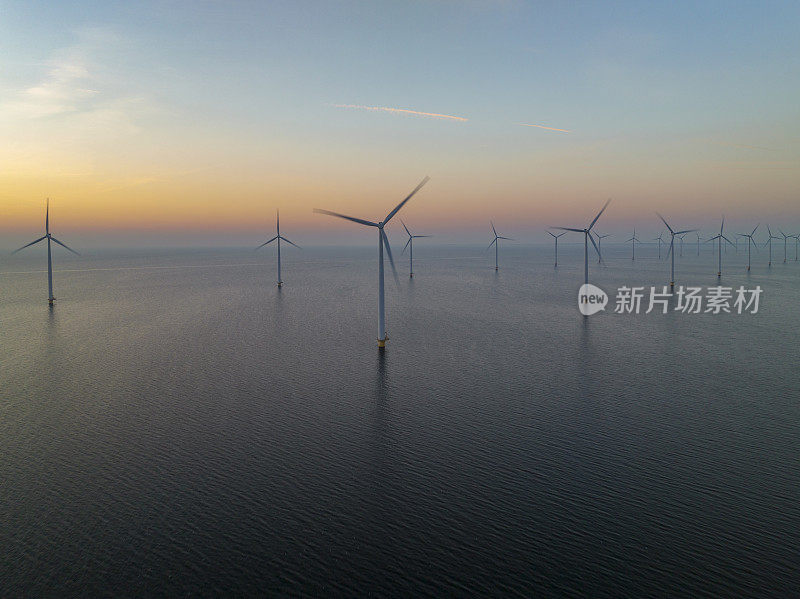海上风电场的风力涡轮机在日落时发电。