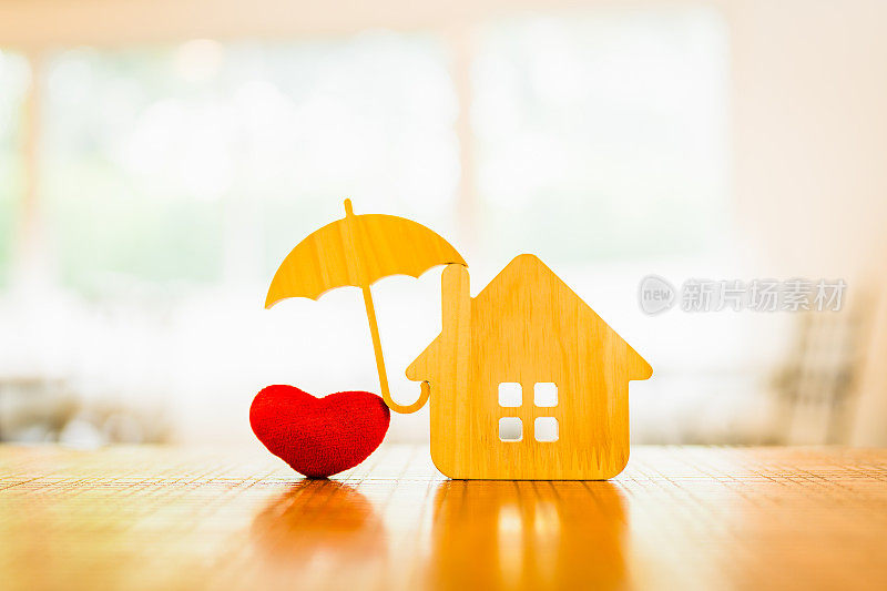 木屋模型和房地产保险的想法，以及小雨伞的心脏模型。房屋灭失和火灾保险，建筑火灾保险概念。