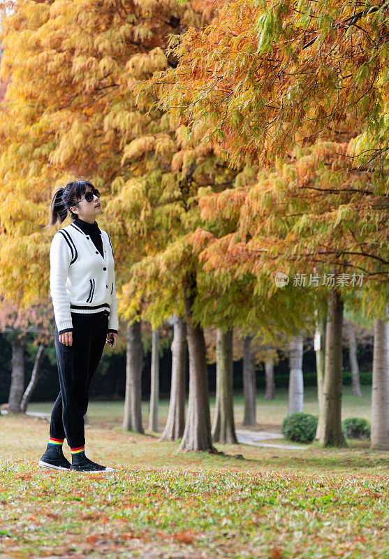 在秋天的公园里散步的女人