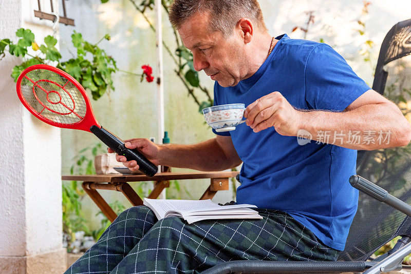 夏日午后，一个人在户外看书，喝咖啡，用电苍蝇拍抓蚊子