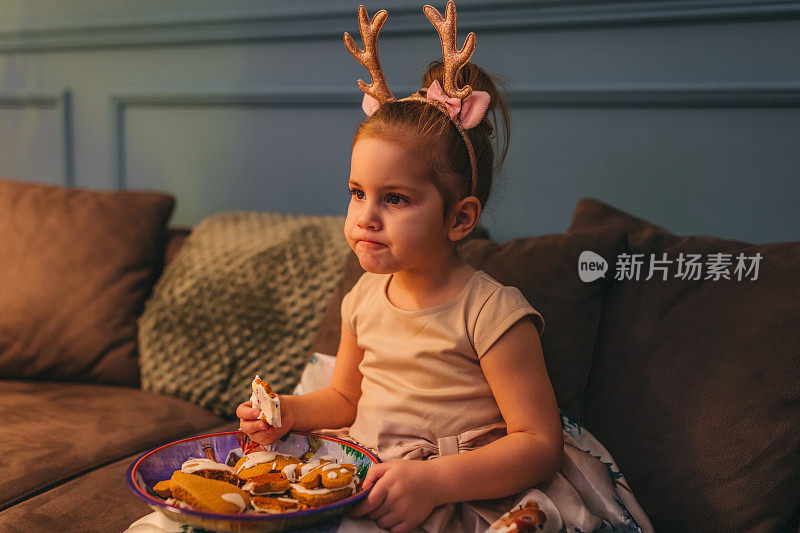 可爱的小女孩在吃圣诞饼干