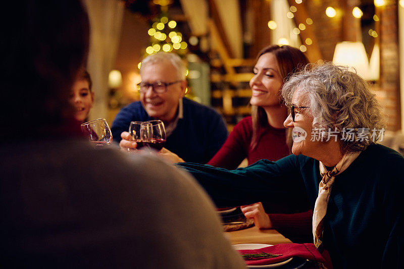 快乐的大家庭在圣诞晚餐餐桌上敬酒。