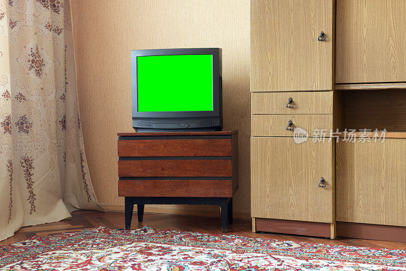 古色古香的木柜上的绿屏古色古香的电视，老旧的设计风格在一个房子里，有八九十年代的风格。