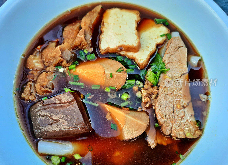 香脆五花肉和水煮蛋的棕色汤面卷——曼谷街头小吃。