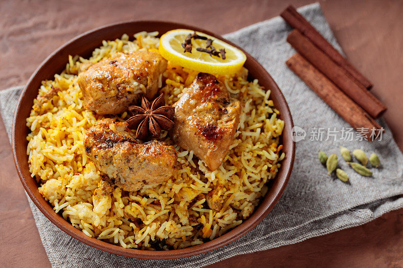 印度香辣鸡肉香饭配八角茴香，肉桂棒和柠檬，时髦的印度和巴基斯坦食物
