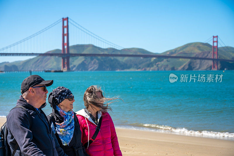 三个成年人在普雷西迪奥海滩上散步