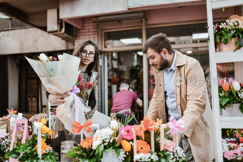 美丽的女花店为她的新顾客制作花束