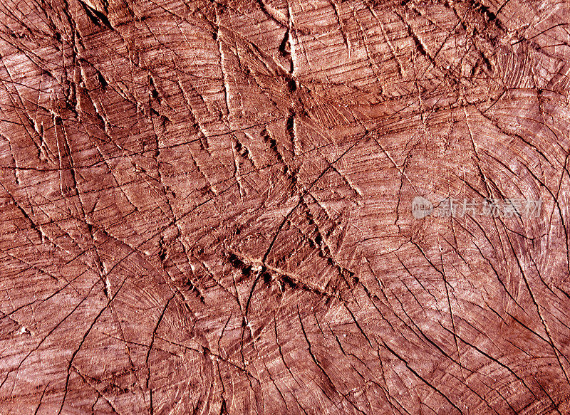 抽象红色色调的老树表面用斧头划痕。