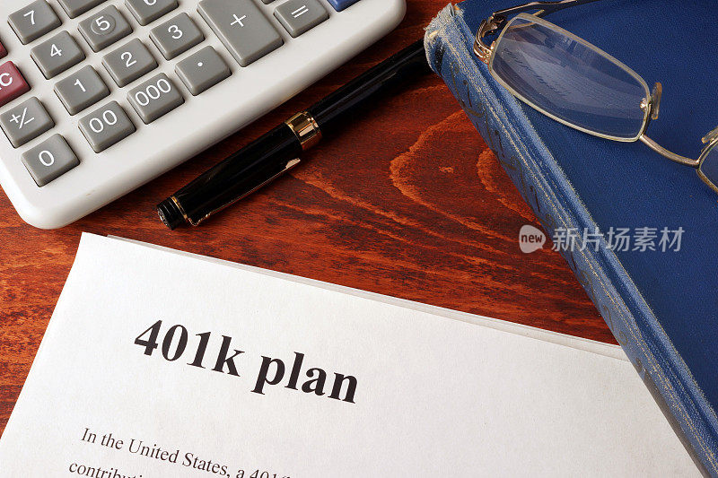 桌子上有401k计划和书的文件。