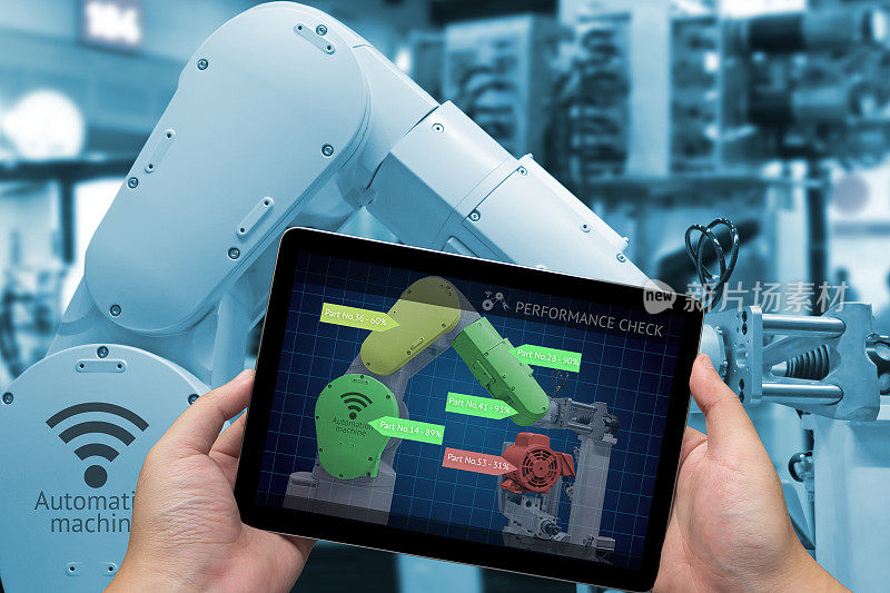 工业4.0概念。带性能检查屏幕软件的手动平板电脑和智能工厂背景下的自动化无线机器人手臂的蓝色调