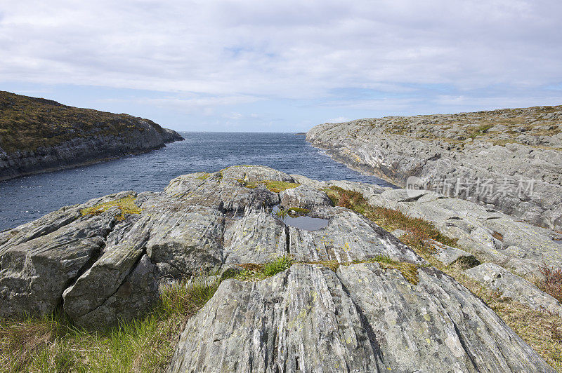 挪威戈尔登的岩石海岸，春天平静的海水