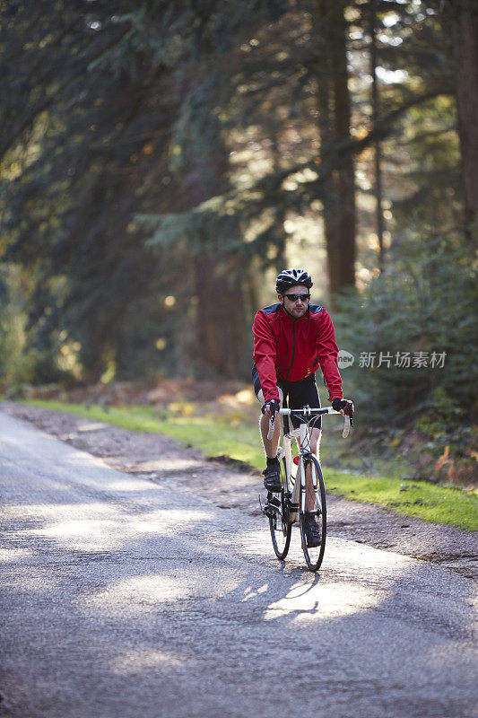 骑自行车的人在穿过森林的路上
