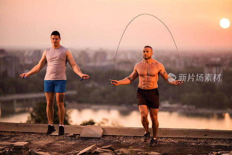 两个运动员在日落时跳绳和锻炼。