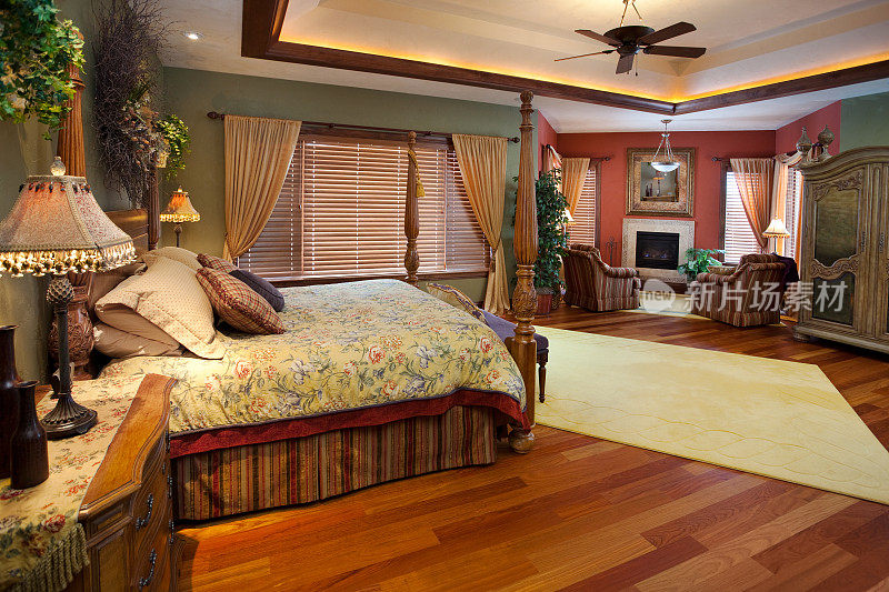 宽敞的主卧室设有休息区，有照明的托盘天花板